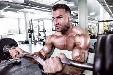Halter alıştırmalar yapan kaslı vücut geliştirmeci adam
