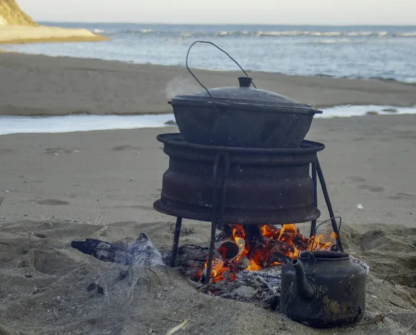 outdoor dinner - fried meat in a pan on a fire