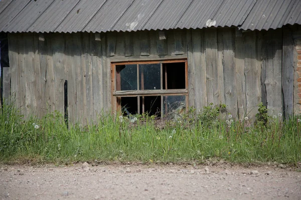 Altes Holzhaus mit zertrümmertem Fenster — Stockfoto