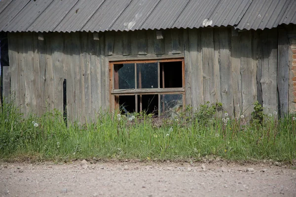 Oude houten huis met gebroken raam — Stockfoto