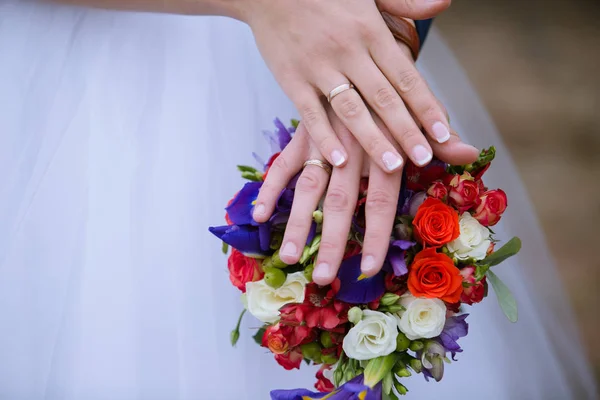 Wedding bouquet - groom and bride's hands — Stock Photo, Image