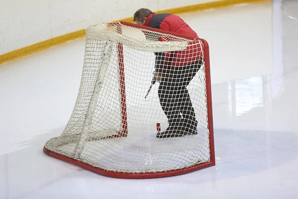Trabajador con un taladro establece una puerta de hockey Fotos De Stock