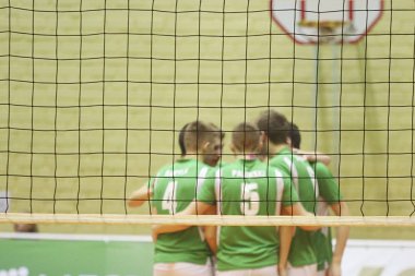 Voleybol oyuncuları voleybol ağının arka planında