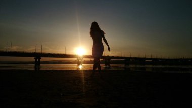 Köprünün gün batımında bir kız