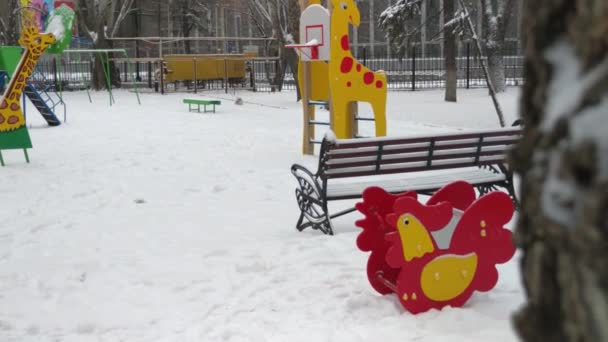 Ein Spielzeug Auf Dem Spielplatz Ohne Menschen Kinderauto Schnee Wiegt — Stockvideo