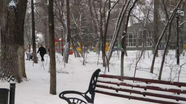 Passante Passa Davanti Parco Giochi Sta Nevicando Osservazione Uomo Dietro — Video Stock