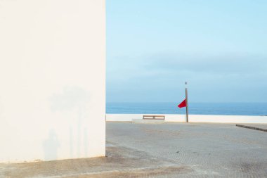 Kırmızı bayrak ve beyaz duvarlı deniz ufku bileşimi