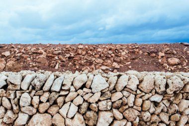 Kırmızı toprak, beyaz kayalar ve bulutlu mavi gökyüzünün soyut organik yatay bileşimi
