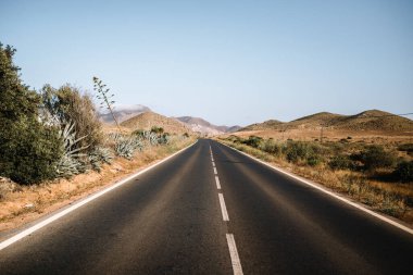 Çölde kaybolan otoban sonsuz dağlarda bulutsuz mavi gökyüzü