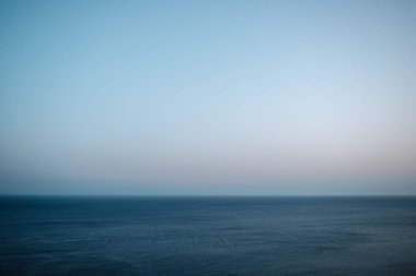 Deniz ve ufkun minimalist görüntüsü koyu mavi deniz ve büyük bulutsuz mavi gökyüzü
