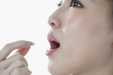 Gülümseyen kadın hap alıyor 