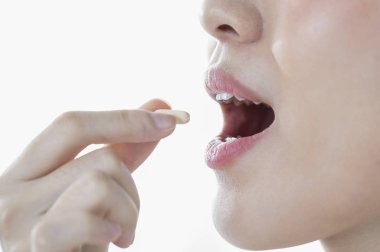 Gülümseyen kadın hap alıyor 