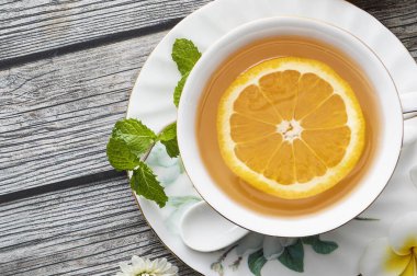 Limon ve nane yapraklı bir fincan çay.