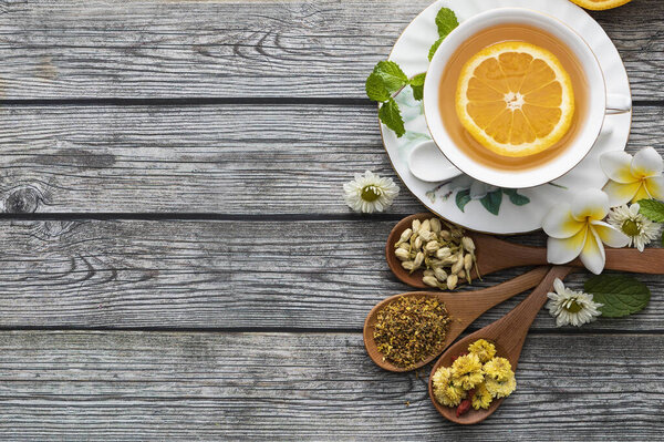 cups of herbal tea with mint leaves and chamomile flowers