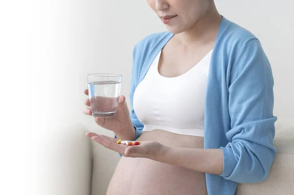 正在吃药的年轻亚洲孕妇 — 图库照片