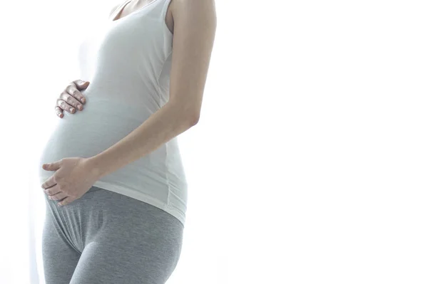 年轻的孕妇站在半圈 紧紧抓住肚子 — 图库照片