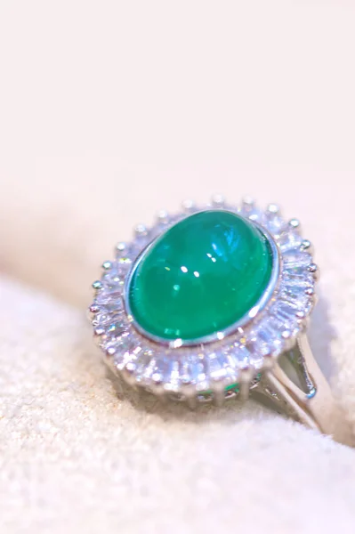 beautiful ring with green gem on a white background