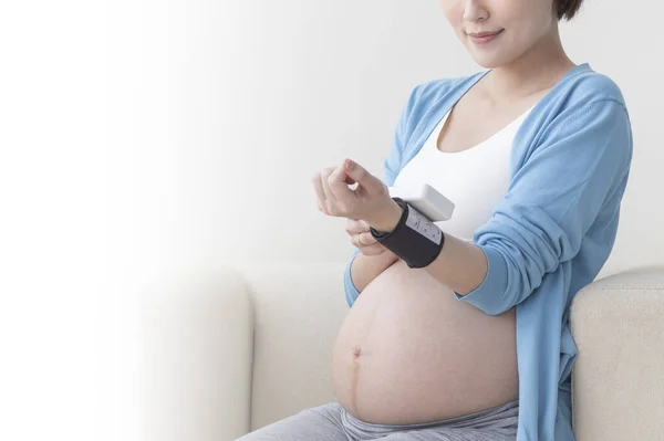 若いアジアの妊婦は彼女のパルスを測定 — ストック写真