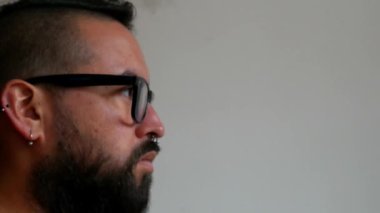 Sakallı adam yüz maskesi takıyor.