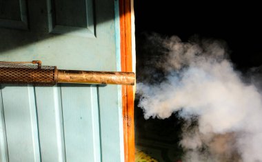 Bir adam Zika virüsünün sivrisinek taşıyıcısını öldürmek için dezenfekte sivrisinekleri kullanıyor ve okulda dang humması salgını ve yağmur mevsiminde evler. Duman sivrisinekleri öldürmek için kullanılır..