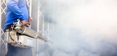 Bir adam Zika virüsünün sivrisinek taşıyıcısını öldürmek için dezenfekte sivrisinekleri kullanıyor ve okulda dang humması salgını ve yağmur mevsiminde evler. Duman sivrisinekleri öldürmek için kullanılır..