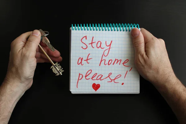 Erkeklerin elleri not defterini tutsun. Evde kalın, lütfen. Evin anahtarlarını da. Koronavirüs Covid-19 salgınından dolayı karantina ya da kendini izole etme. Siyah arkaplan