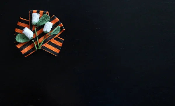 9 Mayıs 2020 tarihli kavram geçmişi - Büyük Vatanseverlik Savaşı 'nın 75 yıllık zaferi. St. George kurdelesinde el yapımı çiçekler. Siyah arka planda izole edilmiş. Anma günü. Tebrik kartı. Boşluğu kopyala