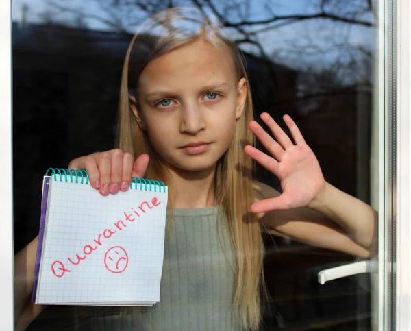 Daire penceresinin arkasındaki sarışın bir kızın bulanık portresi üzerinde 