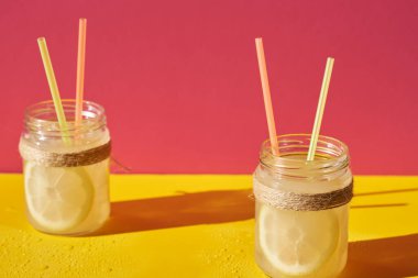 Limon suyunu tazeliyorum. Arkasında pembe ve sarı bir arka plan var..