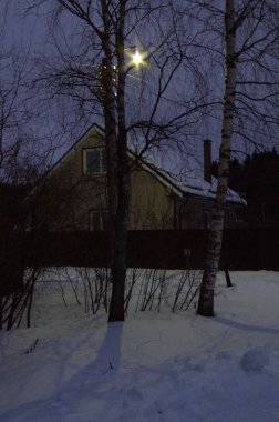Kış geceleri Rus manzara. Kırsal yazlık günbatımı, huş ağaçları, fener, snowdrifts sonra.
