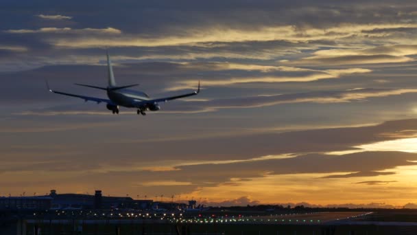 Kereskedelmi repülőgépek barcelonai repülőtéren leszálló naplemente — Stock videók