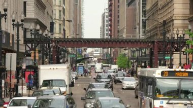 Şehir merkezinde trafik Chicago sokaklarında. Araçlar ve yayalar kalabalık Chicago şehir merkezi. Hafta içi geçiş yükseltilmiş metro trenleri ile döngü hayat. Bir sürü araba ve taşıt Illinois. Sokaklarda insan faaliyetleri.