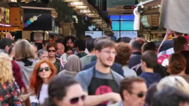 Crowd Shopping in La Boqueria Market in Barcelona.  Crowds of tourists in Barcelona. Tourists visiting in Barcelona in Autumn. Crowded La Boqueria fresh market. Crowds of people walking on the market. — Stock Video