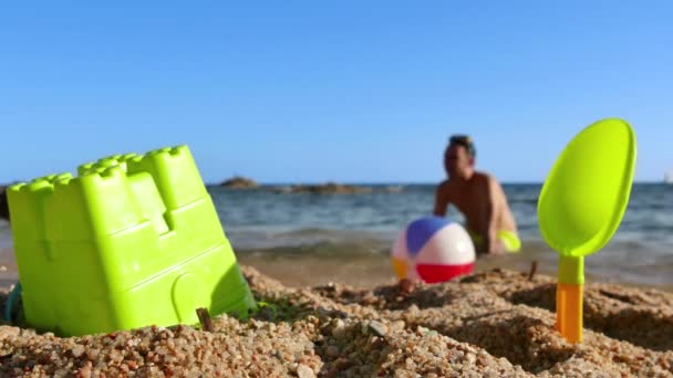Отец и сын играют в мяч на пляже — стоковое видео