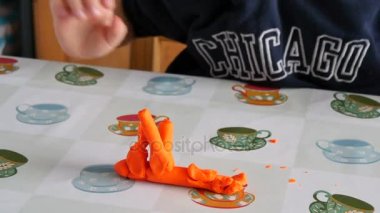 Çocuk el sanatları evde yapıyor. Güzel bir çocuk ellerle hamuru şekillendirme. Eğleniyor öğrenci el sanatları yapıyor.