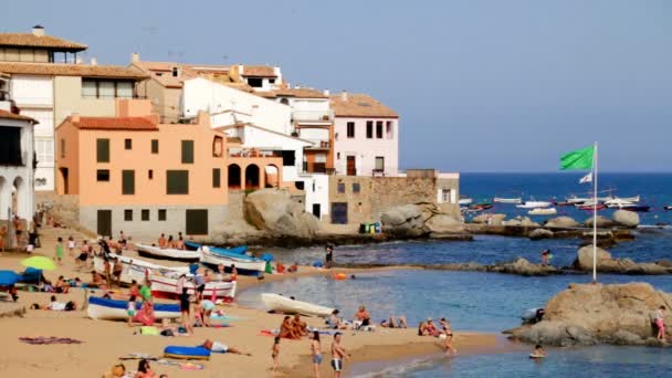 夏天在海滩在太阳之下在西班牙 典型的地中海海滩在夏天天 在海边度假的人们 在海边的闲暇时间 绿松石清澈的海水 海滩上的假日场景 有日光浴的场面 休息的人在 — 图库视频影像