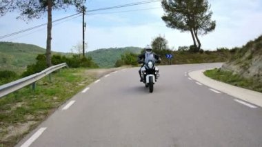 Onun spor motosiklet sürüş bir Curvy yolda motosikletçi. Genç bir adam onun enduro motosiklet bahar ile sabit cam kadeh. Eylem, İspanya manzaralı bir yolda bir çapraz motosiklet önden görünümü.