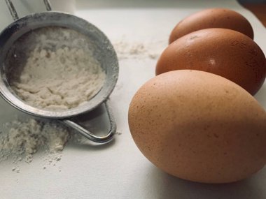 Beyaz arkaplanda yumurta ve un. 