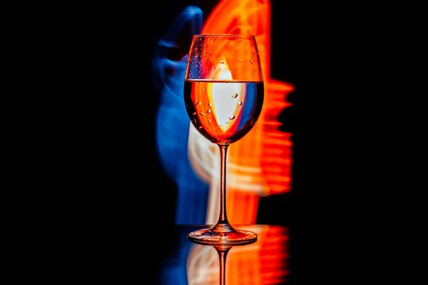 Glas für Wein vor dem Hintergrund heller Farblösungen — Stockfoto