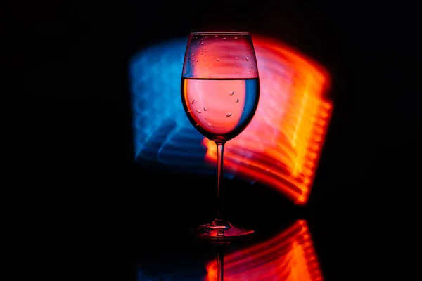 Glass for wine against the backdrop of bright color solutions — Stock Photo, Image