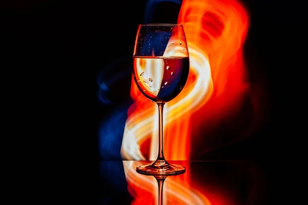 Glas für Wein vor dem Hintergrund heller Farblösungen — Stockfoto