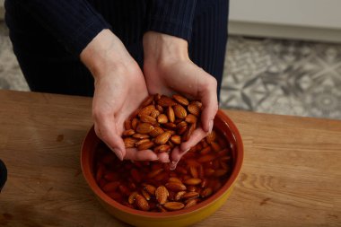 Kız badem pişirir ve badem sütü yapar.