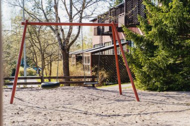 Çocuklar bir yerleşim köyünde boş salıncak sallıyor..