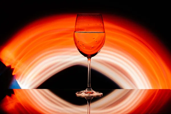 Glas für Wein vor dem Hintergrund heller Farblösungen — Stockfoto