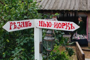 New York 'un sağında, Ryazan' ın solunda çizgi roman ahşap yön işaretçisi