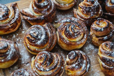 Tahtaya pudra şekeri serpiştirilmiş tarçınlı rulo.