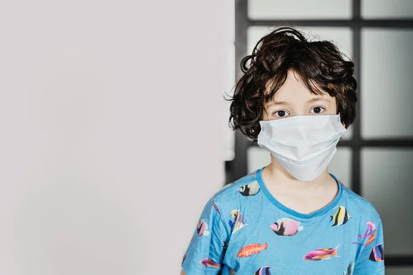 Un niño de 7 años lleva una máscara quirúrgica. Fotos De Stock