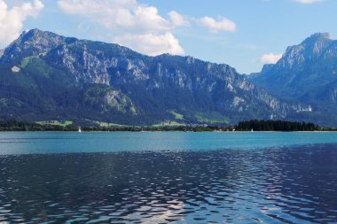 Mavi büyük bir göl kenarındaki güzel, büyük tepeler.
