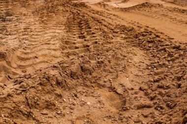 Kumda büyük arabaların lastik izleri var.