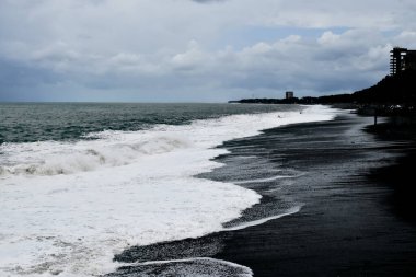 Alacakaranlıkta kara kum ve deniz